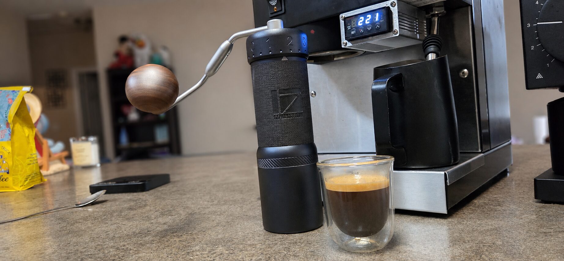 1Zpresso J-Ultra hand grinder beside a fresh shot of espresso