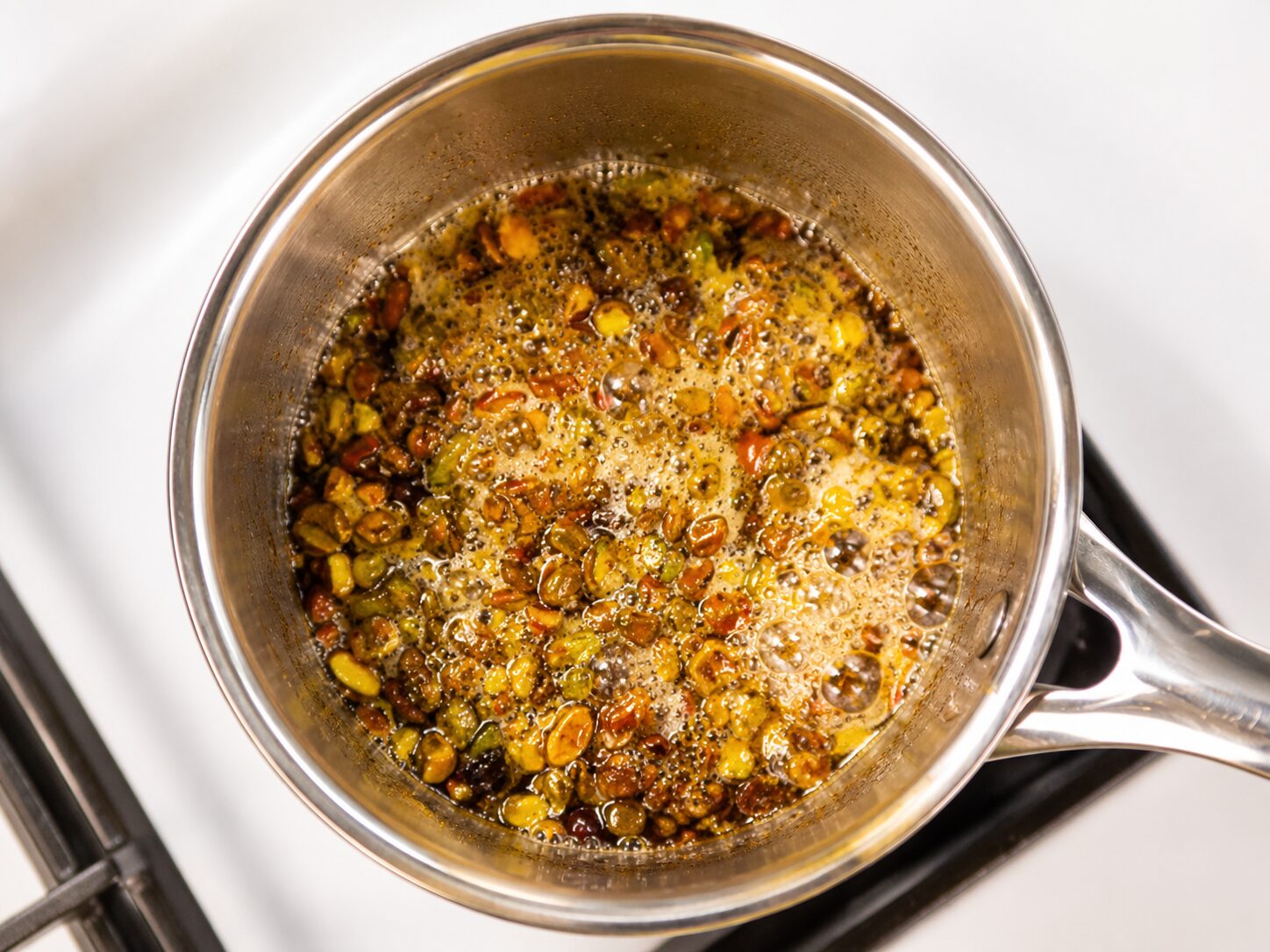 Pistachio syrup steeping in a covered saucepan