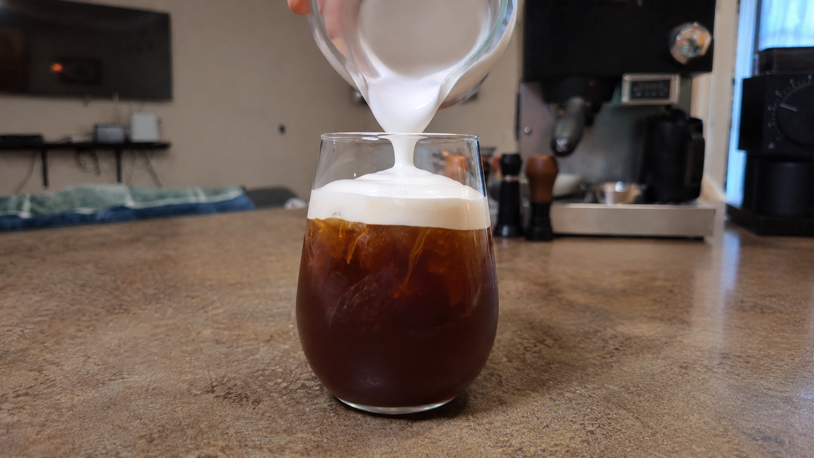 Cold foam made with the Instant Milk Frother poured over iced coffee